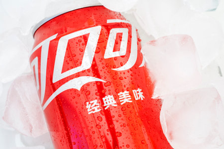 BERLIN - OCT 14: Chinese Coca-Cola beverage in classic red can with ice cubes in Berlin, October 14. 2022 in Germanyのeditorial素材
