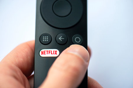 BERLIN - NOV 10: Close-up of button with Netflix logotype on a TV remote in Berlin on November 10. 2022 in Germany. Netflix Inc. is an American subscription streaming service and production company.のeditorial素材