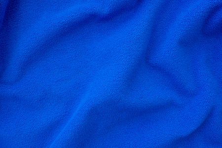 Bright blue fleece cloth. Crumpled, folded blue cloth as background or backdrop, top viewの写真素材
