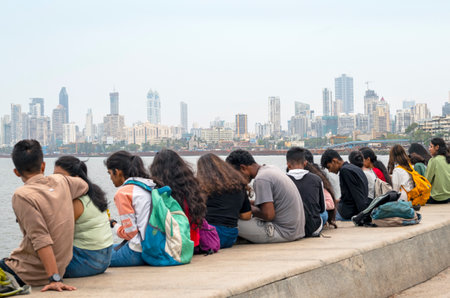 MUMBAI - SEPTEMBER 25: People sitting along the Marine Drive or Queens Necklace promenade in Mumbai on September 25. 2022 in Indiaのeditorial素材