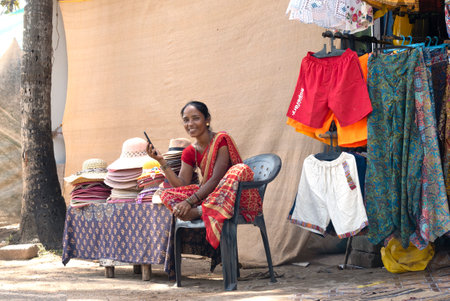 AGONDA GOA - SEPTEMBER 26: Indian woman street seller at a small clothing store in Agonda, on September 26. 2022 in Indiaのeditorial素材