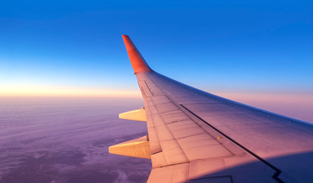Panoramic cabin view through an airplane window. Aircraft flight above land and blue sky with space for textの写真素材