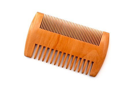 Small brown wooden comb for hair of beard isolated on whiteの写真素材