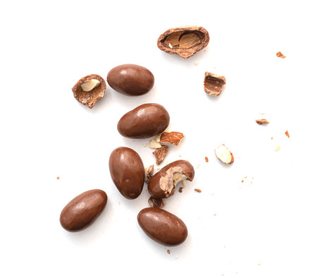 Round and broken small chocolate candies with almond, nuts as filling isolated on white, top viewの写真素材