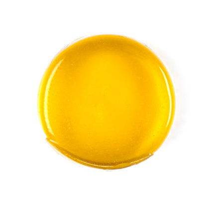 Close-up of round yellow medical lozenges for sore throat with honey tast isolated on white, top viewの写真素材