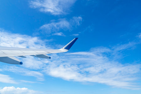 View to the airplane wing and blue sky through a window, space for textの写真素材