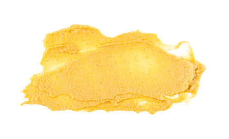 Yellow abstract smear of mustard sauce isolated on white, top viewの写真素材