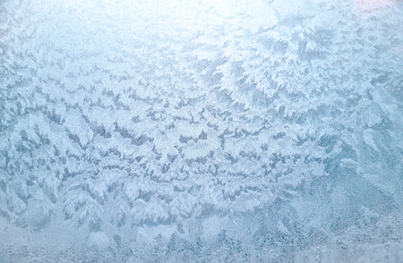 Winter window with frozen surface, icy pattern as background or texture. Abstract winter patterns snow on glassの写真素材