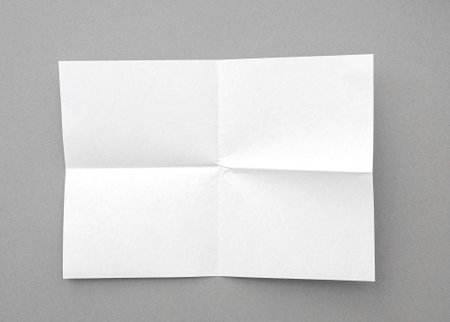 White blank folded page, sheet on gray backgroundの写真素材