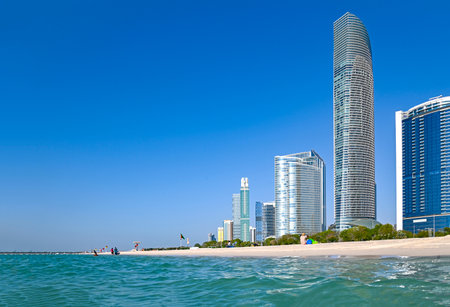 Panoramic view of Abu Dhabi with sea, sand, skyscrapers against blue skyの写真素材