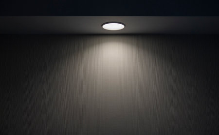 Ray of light from round compact lamp in dark room during night timeの写真素材