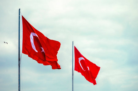 Two Turkish flags, flags of Turkey in a street against skyの写真素材