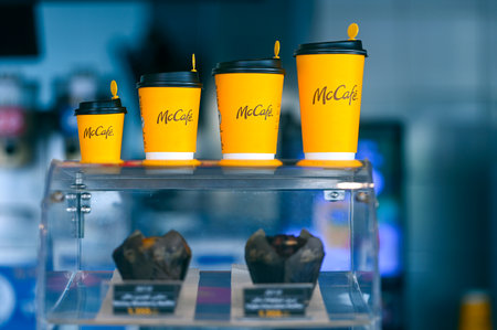 MUSCAT - SEPT 19: Showcase with row of yellow paper cups for hot beverages in McCafe in Muscat on September 19. 2024 in Omanのeditorial素材