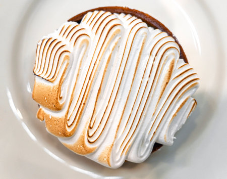 Round small cake with white cream on plate, top viewの写真素材