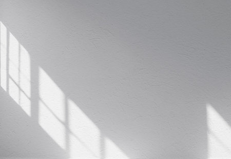Simply white wall with reflection by window during sunny day. Space for text.