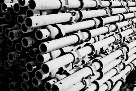 scaffolds of standard vertical tubes made of metal in monochrome