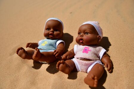 dolls for boys are sitting in the hot sandの写真素材