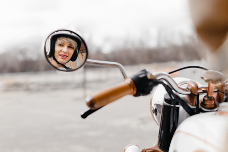 The girl on a motorcycle . Displaying girls in the mirror of the motorcycle.の写真素材