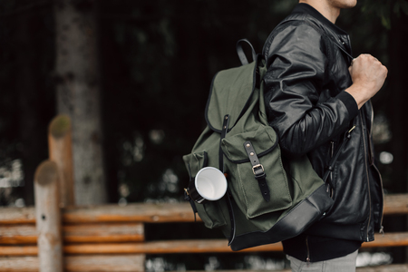 The man in the woods. Male with a black backpack and a mugの写真素材