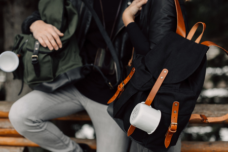 Man and woman in the woods. Man and woman with backpacks and mugs. Mugs hang on the backpack. Journey. Forestの写真素材