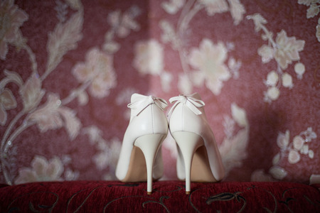 Elegant bridal shoes standing on a chair.の写真素材
