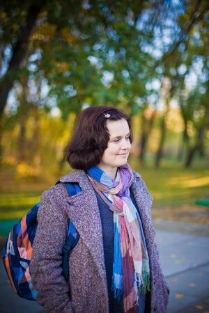 Happy woman walking outdoors on an autumn day.の写真素材