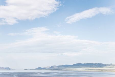 background with a mountain landscape, the storm sky and blue water  の写真素材
