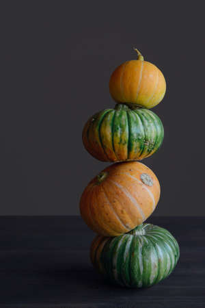 pyramid of small yellow and green pumpkins on a wooden table, close upの写真素材