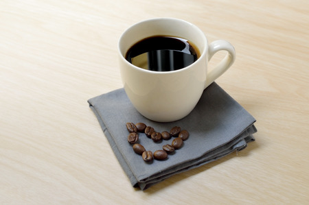 Espresso coffee in small white cups with heart shape made of beanの写真素材