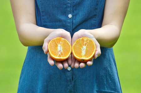 Female hands holding ripe mandarinsの写真素材