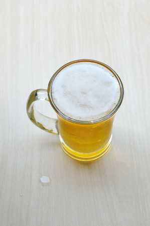 Glass of beer on the wooden table.の写真素材