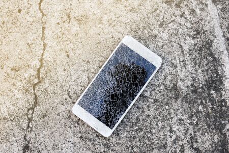 Close up of broken mobile phone drop on cement floorの写真素材