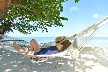 Happy woman in hammock on tropical paradise beachの写真素材