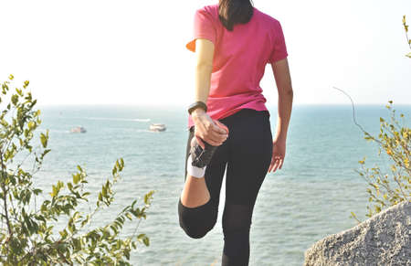 Woman runner warm up before taking a jogging on beach