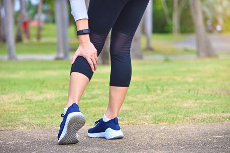 Young woman feel pain on her leg while exercisingの写真素材