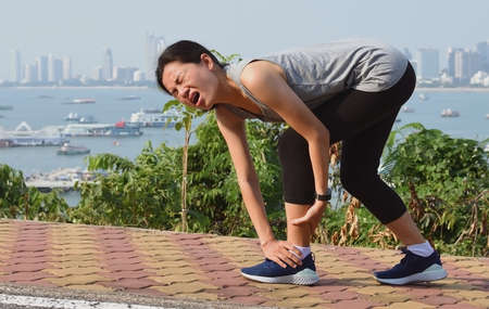 Running woman screaming in pain during running training.の写真素材