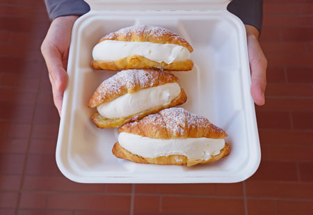 Fresh croissants with cream cheese  in  delivery box.