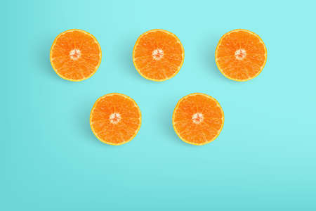Slices of delicious oranges on bright light blue background.の写真素材
