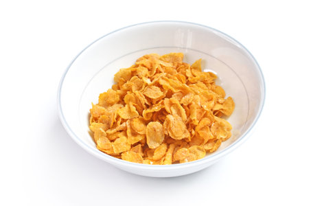 Bowl with crispy cornflakes on white background, top view
