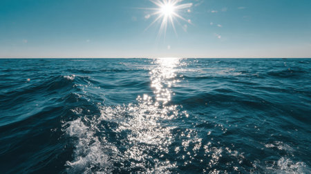 Bright reflection of sun on calm ocean waves during clear dayの素材