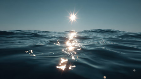 Bright reflection of sun on calm ocean waves during clear dayの素材