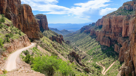 A steep mountain pass with a winding road cutting through towering peaks.の素材