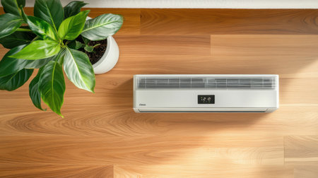 Top view of modern AC remote showing fan speed and cool mode next to potted plantの素材