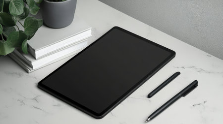 Tablet with stylus beside a stack of notebooks and gel pens on a deskの素材