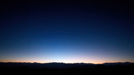 Breathtaking twilight scene featuring a range of majestic mountains silhouetted against a transitioning sky, evoking tranquility and the beauty of nature at dusk.の素材