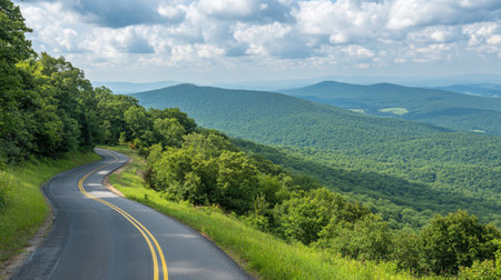 A picturesque view of a winding road through vibrant green mountains under a bright sky, showcasing the beauty of nature and inviting exploration.の素材