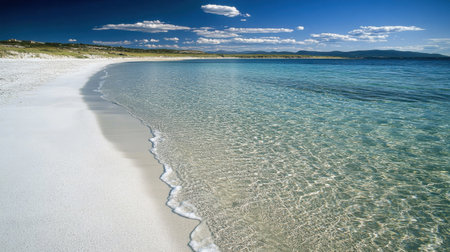 This stunning seashore scene captures crystal-clear water meeting soft white sand under a bright blue sky. A perfect setting for relaxation and tranquility.の素材