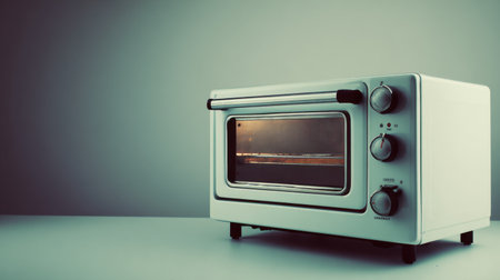 This retro toaster oven highlights a sleek design with functional dials and a warm light, perfect for a minimalistic kitchen. Ideal for versatile cooking.の素材