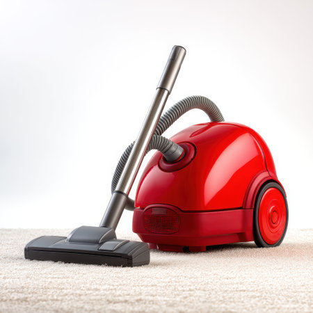 A bright red vacuum cleaner is displayed on a soft carpet surface, showcasing its sleek design and efficient cleaning capabilities for everyday home maintenance tasks.の素材