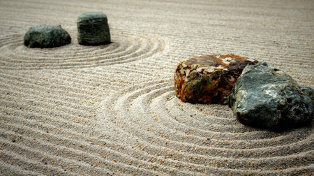 A peaceful Zen garden featuring smooth stones and meticulously raked sand, creating soothing patterns that promote tranquility and meditation for the mind and soul.の素材